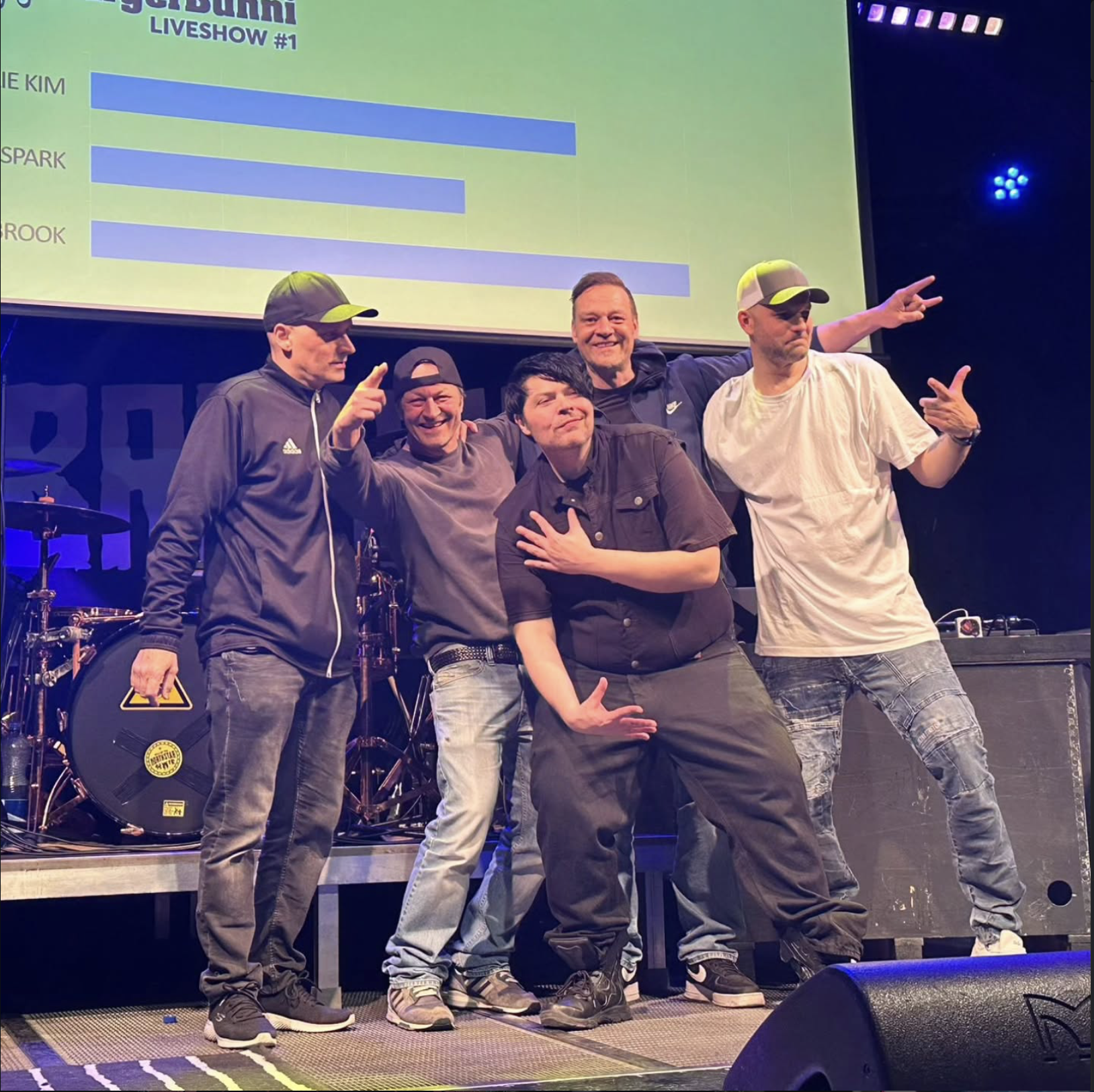 BROOK standing together on stage, celebrating after a show